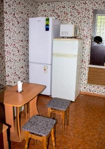 a kitchen with a table and a white refrigerator at Matras Hotel in Kyiv