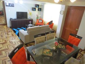 a living room with a couch and a table and chairs at Apartamento Familiar QUEWE in Cusco