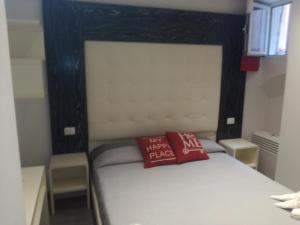 Una cama con una almohada roja encima. en Affittacamere Ca' Dei Lisci, en Riomaggiore