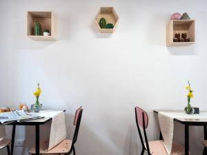 2 Tische und Stühle in einem Zimmer mit weißen Wänden in der Unterkunft Borgodieci in Bibbiano