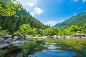 Un río en las montañas con rocas en el agua en Minakamisansou, en Minakami