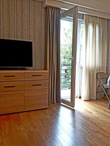 a living room with a television on a wooden dresser at Busas Apartment in Tbilisi City