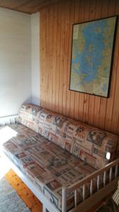 un sofá en una habitación con un mapa en la pared en ILO107 en Huhus