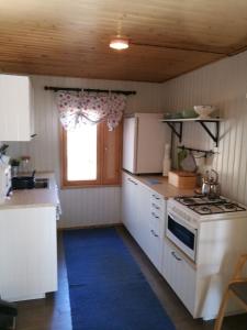 a kitchen with white cabinets and a stove and a window at ILO107 in Huhus