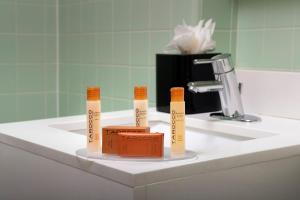 a bathroom sink with three test tubes on it at American Inn of Bethesda in Bethesda