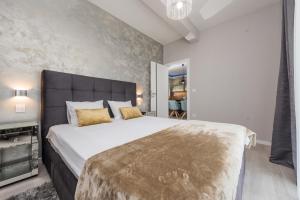 sypialnia z dużym białym łóżkiem ze złotymi poduszkami w obiekcie Luxury Apartments Marija w Sukošanie