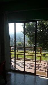 una puerta abierta a un balcón con vistas a un campo en Otentik guesthouse, en Mbabane