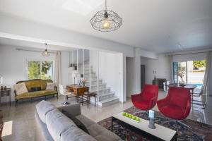 un soggiorno con divano e sedie rosse di Villa Serene a Ayia Napa