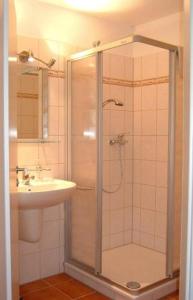 y baño con ducha y lavamanos. en Altes Doktorhaus - Hotel Garni, en Willingen