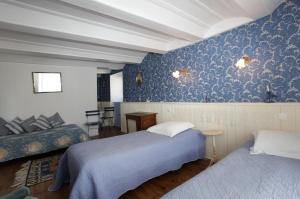 Beaune-sur-Arzon的住宿－le clos saint François，一间卧室配有两张床,铺有蓝色的壁纸。