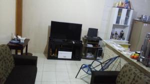a living room with a flat screen tv on a counter at Casa e Suites in Aparecida