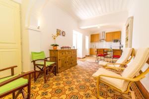 ein Wohnzimmer mit Stühlen und eine Küche in der Unterkunft Casa Adelina By Algartur in Tavira