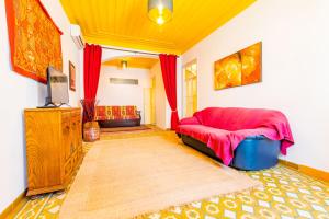 ein Wohnzimmer mit einem roten Sofa und einem TV in der Unterkunft Casa Adelina By Algartur in Tavira