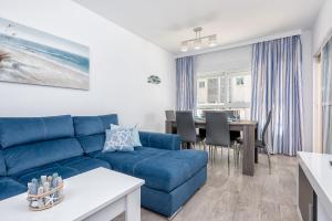 Una sala de estar con un sofá azul y una mesa. en Nuevo Rincon, en Rincón de la Victoria