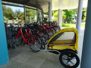 um grupo de bicicletas estacionadas num edifício com um carrinho em Hotel Ker Juliette em Pornichet