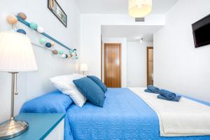 Schlafzimmer mit einem Bett mit blauer und weißer Bettwäsche in der Unterkunft Nuevo Rincon in Rincón de la Victoria