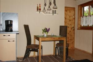 a kitchen with a wooden table and two chairs at Landhaus Lex in Füssen