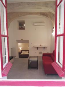 a living room with a red couch and a table at Vallettastay Casa Zoe in Valletta