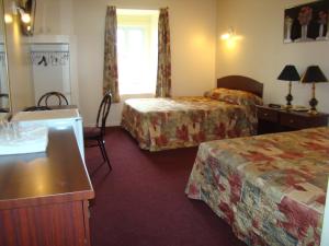 a hotel room with two beds and a table at Hotel Quartier Latin in Montréal