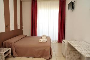 Un dormitorio con una cama con un osito de peluche. en Hotel La Punta, en Otranto