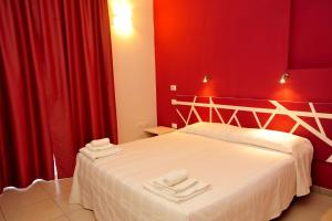 una camera rossa con un letto con due asciugamani di Hotel La Punta a Otranto