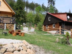 eine Blockhütte mit Picknicktisch und eine Scheune in der Unterkunft Villa Victoria in Kamesznica