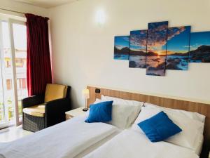 sypialnia z łóżkiem z niebieskimi poduszkami w obiekcie Residence Windsurf w mieście Domaso