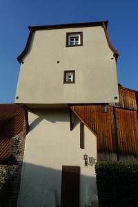 un bâtiment avec deux fenêtres sur son côté dans l'établissement Jocklerturm, à Sulzfeld am Main