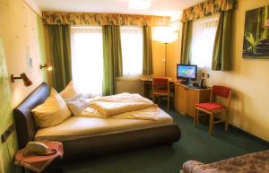 a hotel room with a bed and a desk at Gästehaus Götz in Drobollach am Faaker See