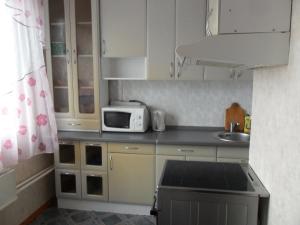 ニジネヴァルトフスクにあるApartment on Mira 15の小さなキッチン(白いキャビネット、電子レンジ付)