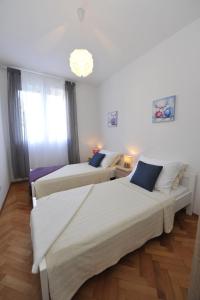 1 dormitorio con 2 camas y lámpara de araña en Apartman Mirakul, en Split