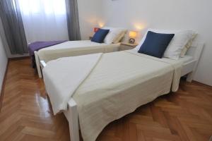 Habitación con 2 camas individuales y suelo de madera. en Apartman Mirakul, en Split