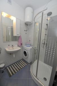 y baño con ducha, lavabo y lavadora. en Apartman Mirakul en Split