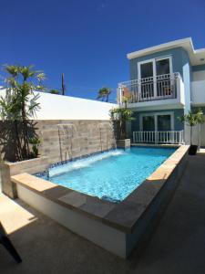 a swimming pool in front of a house at Breeze Point at Ocean in San Juan