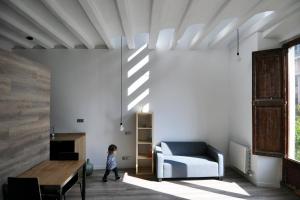 a child walking in a living room with a chair and a couch at apartamento en el centro in Vilanova i la Geltrú