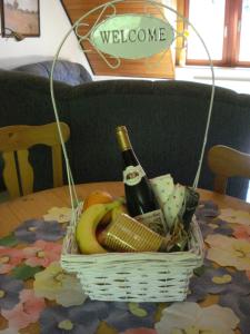 a basket with a bottle of wine and fruit on a table at Ferienwohnung Lydia in Traben-Trarbach