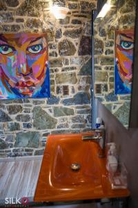 a bathroom with a sink and two paintings on the wall at Trahilas House in Mochlos