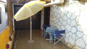 un patio con 2 sillas y una sombrilla en Rooms & Apartments Tepsa - Centre, en Hvar