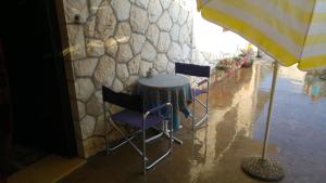 uma mesa e cadeiras debaixo de um guarda-chuva em Rooms & Apartments Tepsa - Centre em Hvar