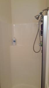 La salle de bains est pourvue d'une douche et d'un mur blanc. dans l'établissement Charming, Private Cottage in Myrtle Creek, à Myrtle Creek 20 autres photos