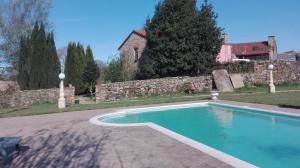 a swimming pool in a yard next to a house at Casa rural osvilares in Santiago de Compostela