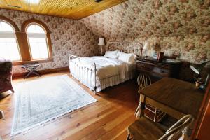 a bedroom with a bed and a desk and a table at Round Barn Farm B & B Event Center in Red Wing