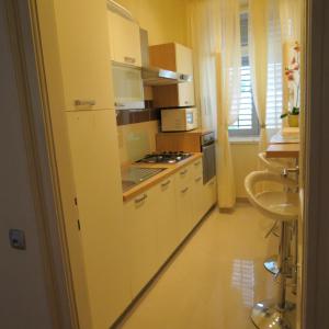 uma cozinha com armários brancos e um forno com placa de fogão em Guesthouse Vrlic em Split