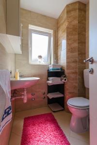 a bathroom with a pink sink and a toilet at Apartments Mijo in Trogir