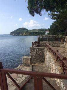 a wooden fence next to a body of water at Villa Nelly by the sea in Néa Koróni