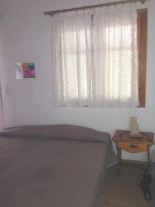 a bedroom with a bed and a window and a table at Villa Nelly by the sea in Néa Koróni +17 photos