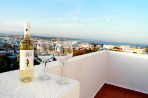 a bottle of wine and two wine glasses on a ledge at Via Dona Ana in Lagos