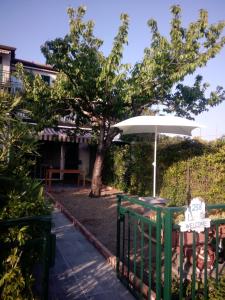 Leivi的住宿－Tigullio Vacations Il Ciliegio Apartment，围栏旁带雨伞的桌子