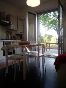 Leivi的住宿－Tigullio Vacations Il Ciliegio Apartment，厨房配有桌椅和窗户。