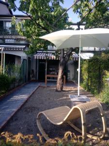 Leivi的住宿－Tigullio Vacations Il Ciliegio Apartment，房屋前带雨伞的长凳